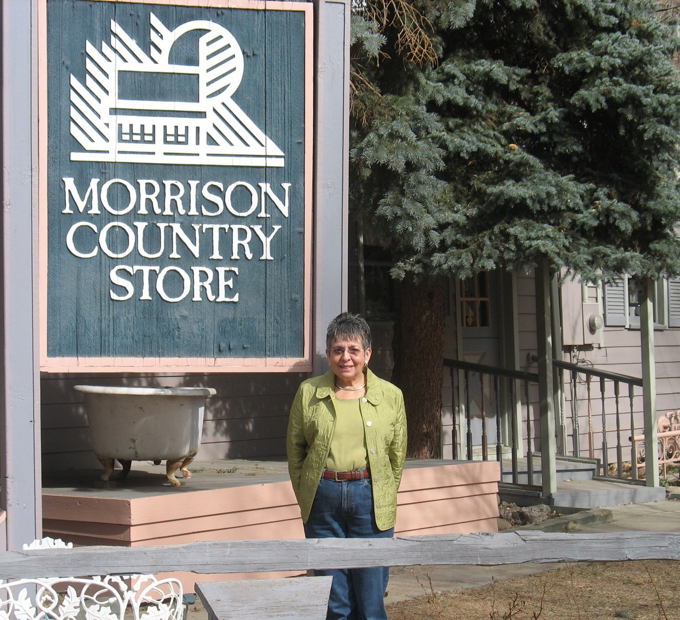 Ginny Paul standing beside the Morrison Country Store sign in 2009.