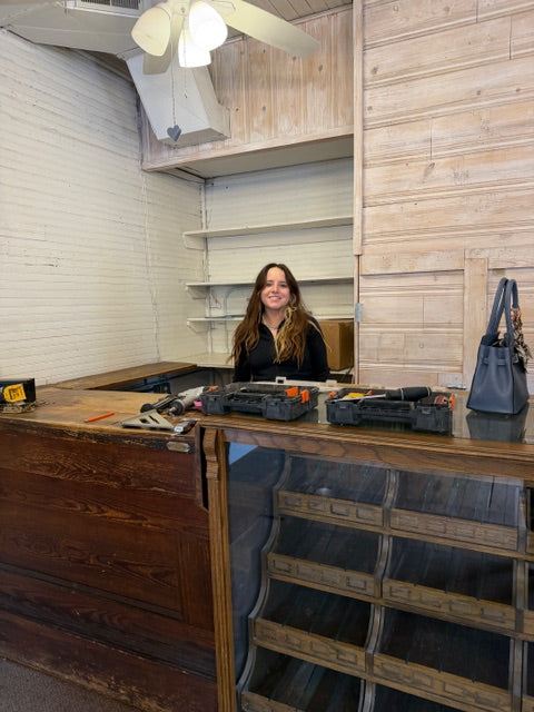 Caroline standing behind the counter at The Little Wren Shop as the shop is coming together